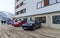 Pair of luxurious sport cars parked outside a hotel near mountains