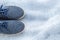 A pair of men`s shoes, blue denim sneakers on a gray background. Comfortable textile footwear. Top view. Casual fashion style