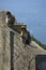 A pair of monkey sitting on a stone fence