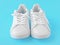 Pair of new white sneakers on blue background. New white leather sneakers sports shoes. sports shoes for running, tennis, jogging