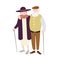 Pair of old man and woman dressed in stylish clothing standing with canes