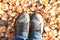 Pair of old shoes on background of autumn leaves