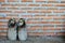 A pair of old shoes on brick wall background, old background, old boots