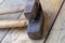 Pair of old tools, close-up steam hammer lies on a wooden background