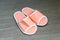 A pair of orange disposable slippers with soft foam texture for