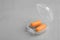 Pair of orange ear plugs in case on grey background. Space for text