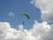 A pair of parachutists on a green parachute in the sky