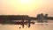 Pair of people in kayaks floats on a calm river in a sunset