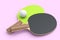 Pair of ping pong rackets for table tennis with ball isolated on pink