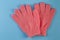 A pair of pink massage gloves for shower on blue background