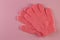 A pair of pink massage gloves for shower on pink background