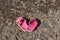 Pair of pink slippers are are on the Beautiful texture of gray and orange broken stone by the pond in the summer day