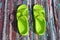 Pair plastic green sandals on handmade carpet background