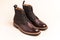 Pair of Premium Dark Brown Grain Brogue Derby Boots Made of Calf Leather with Rubber Sole Placed Over Beige Background