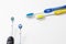 Pair of Professional Electric Toothbrushes Against of Two Manual Tooth Brushes On White Background