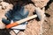 Pair of protective gloves and hammer on stone on construction site. Maruggio, Puglia, Italy