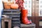 a pair of red boots on a wooden box on the background of a wall and pumpkins