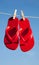 A pair of red flipflops against a blue sky