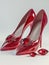 Pair of red leather high heel shoes with ruby gemstones.