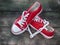 Pair of red sneakers youth on an old wooden surface