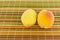 Pair of ripe juicy fruit peaches yellow orange appetizing lunch diet on a background of colorful wooden green light rib strips