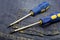 Pair of screwdrivers with blue plastic handle hand tool repairing a home craftsman denim background