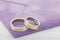 Pair of silver and gold combined rings on purple invitation envelope