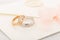 Pair of silver mens ring and pink gold womens ring with diamonds on  invitation envelope