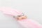 Pair of silver mens ring and pink gold womens ring with diamonds on pink feather