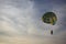 Pair skating on a multi-colored parachute on a leash to the boat, on the sea