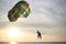 Pair skating on a multi-colored parachute on a leash to the boat, on the sea