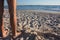 A pair of skinny male hairy legs in summer on the sandy beach in front of the blue sea