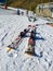 a pair of skis left on the white snow with nobody using them on a skiing scene at the background in a sunny day of winter