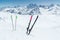 A pair of skis and ski poles stick out in the snow on the mountain slope of the Caucasus against the backdrop of the