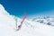 A pair of skis and ski poles stick out in the snow on the mountain slope of the Caucasus against the backdrop of the