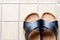 A pair of slipper on skin of black on beige tiles background