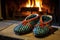 a pair of slippers next to a crackling fireplace