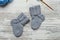 Pair of small woolen socks for newborn on wooden vintage table