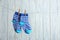 Pair of socks on laundry line against wooden background. Baby accessories