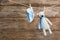 Pair of socks and toy bear on laundry line against wooden background. Baby accessories