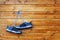 Pair of sport shoes hang on a nail on a brown wooden wall