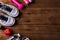 Pair sports shoes, apple, jump rope and dumbbell on wood table