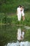 Pair stands on bank of pond