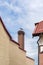 A pair of storks builds a nest on a chimney at home against a blue spring sky. Kaliningrad region, Russia