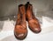 Pair of stylish brown leather boots closeup shot. Laces, white background