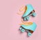 Pair of stylish quad roller skates on color background, top view