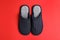 Pair of stylish slippers on red background, top view