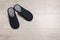 Pair of stylish slippers on white wooden floor, top view. Space for text