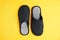 Pair of stylish slippers on yellow background, top view