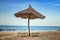 Pair of sunbed with parasol on beautiful empty beach near clear sea. It is a tropical paradise in Africa, Senegal. There is blue